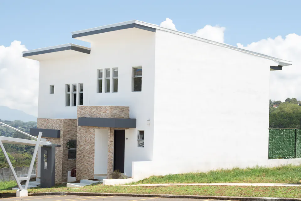 Two-storey white house at Condominio Milenia with a lawn