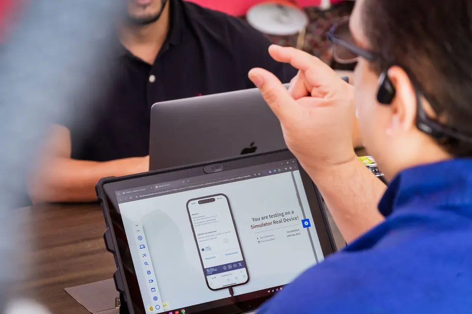 Team testing a website on a real iPhone from a tablet during a meeting